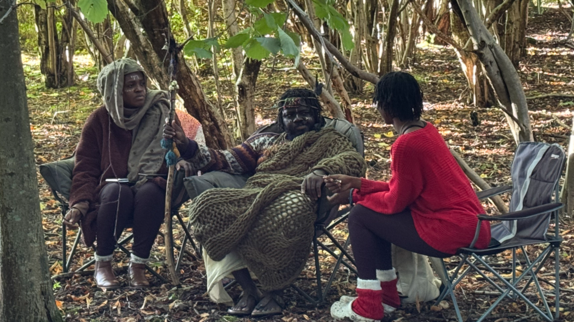 The three members of the self-proclaimed Kingdom of Kubala, clothed in knitwear, sit in camping chairs in woodland following their eviction. 