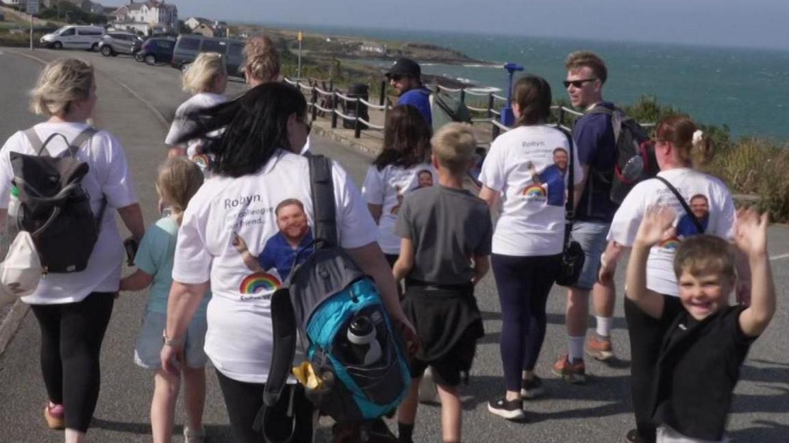 Roedd rhai o gydweithwyr Robyn wedi gwisgo crysau-t arbennig ar y daith