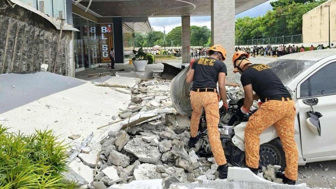 fire officers removing debris outside a shopping mall following an earthquake in Butuan city, Caraga region, Philippines, 10 October 2025. 