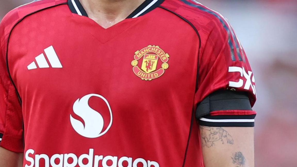 A Manchester United player wearing a black armband