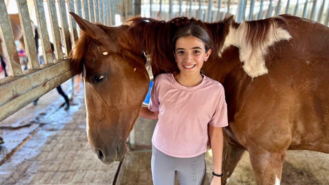 Shams stands in front of her horse Calypso