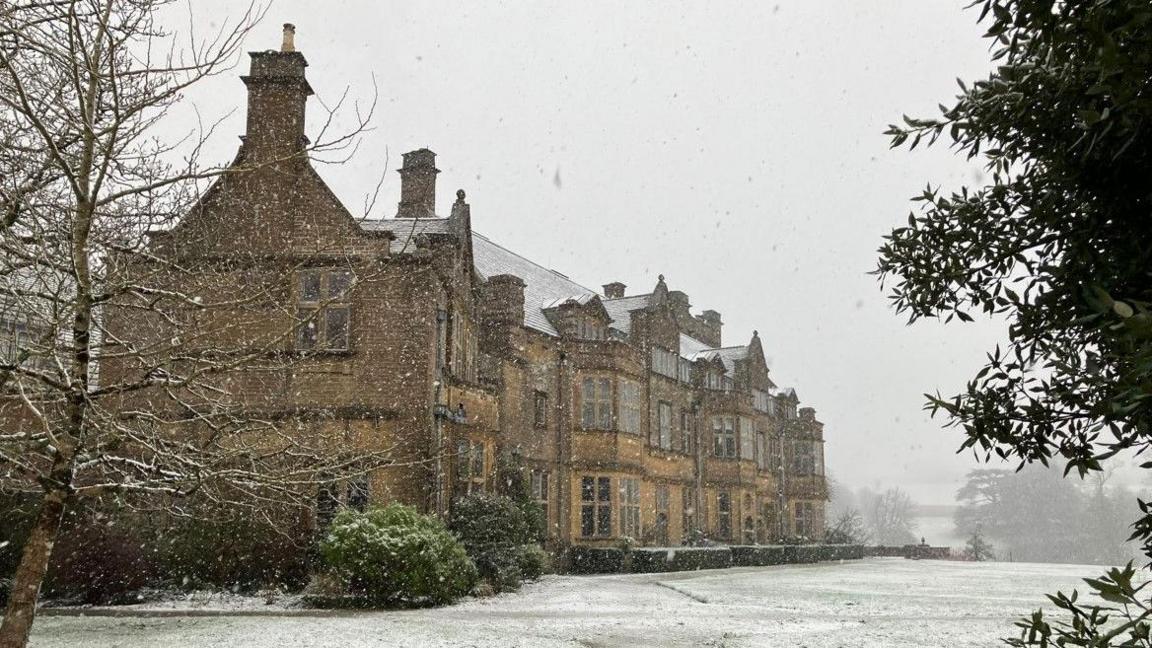 Minterne House in the snow. A large sandstone stately home.