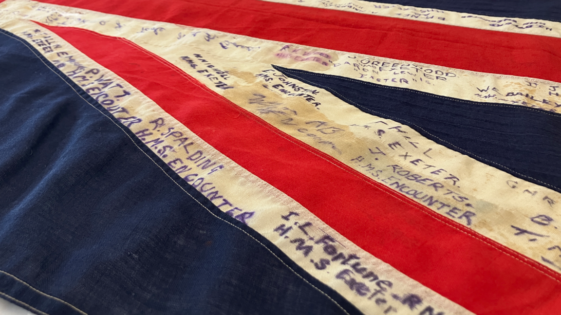 The flag with names written in pen in capital letters on the white strips