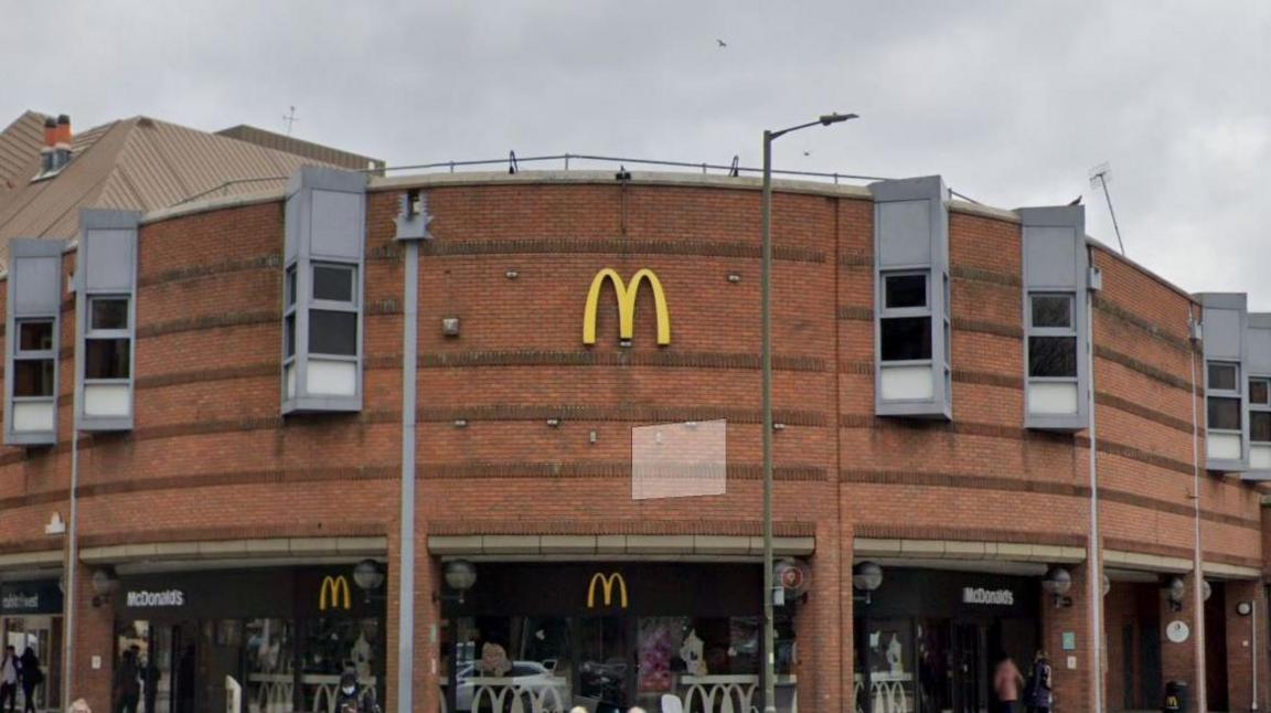 A McDonald's logo on a modern red brick building. 