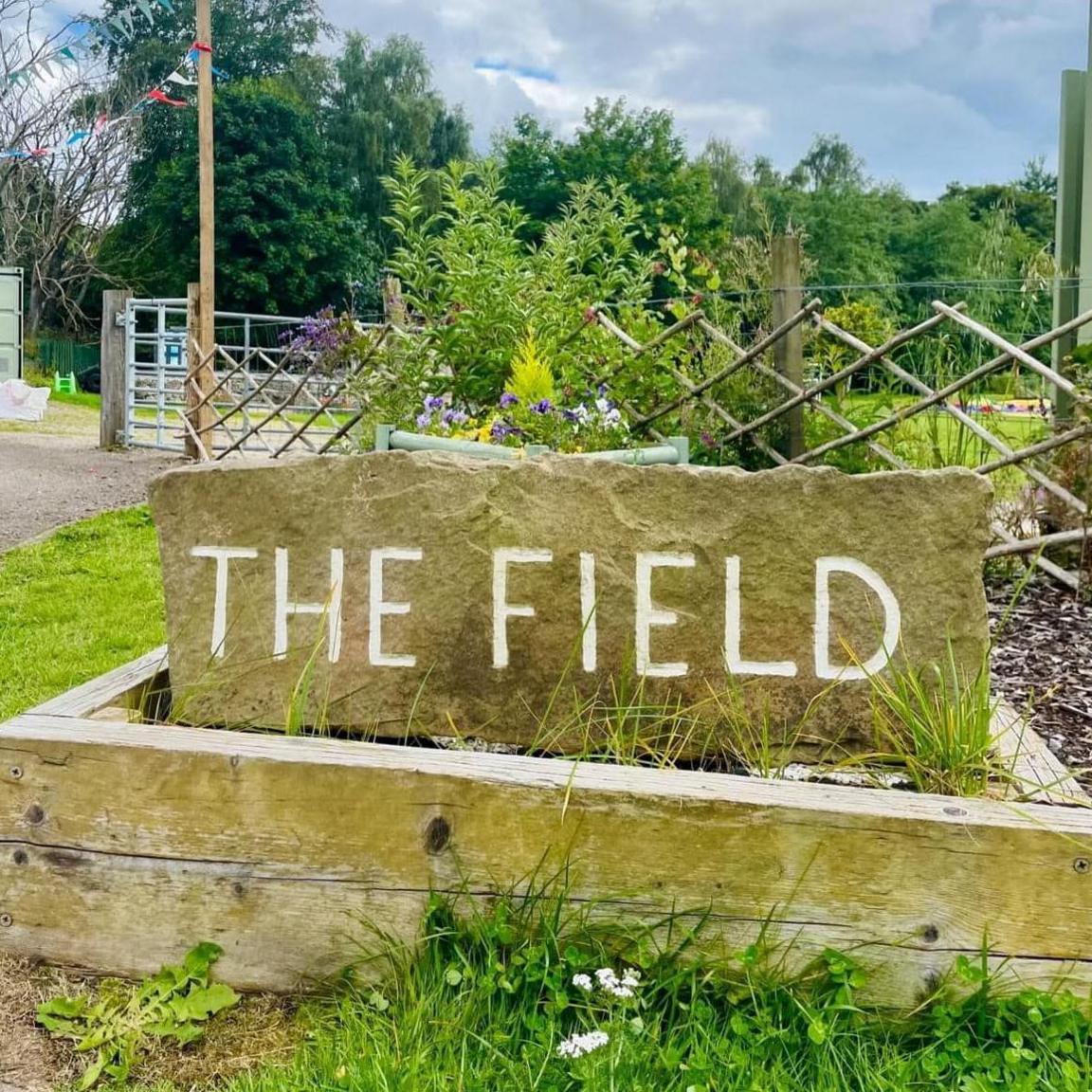 A sign reading "The Field" at The Field community space in Alness