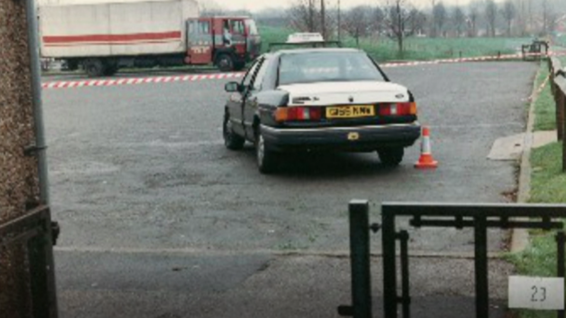 An archive picture of the crime scene in Gedling. It depicts a police cordon, as well as a taxi