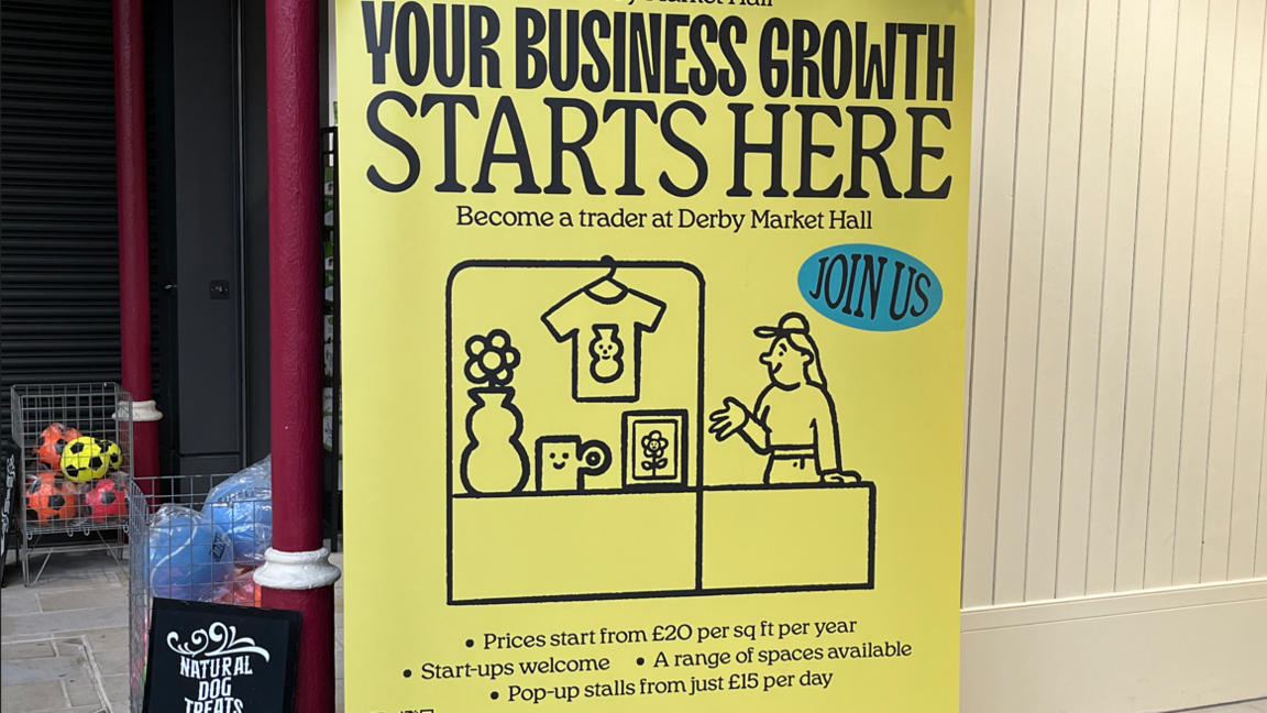 A yellow advertisement board in Derby Market Hall
