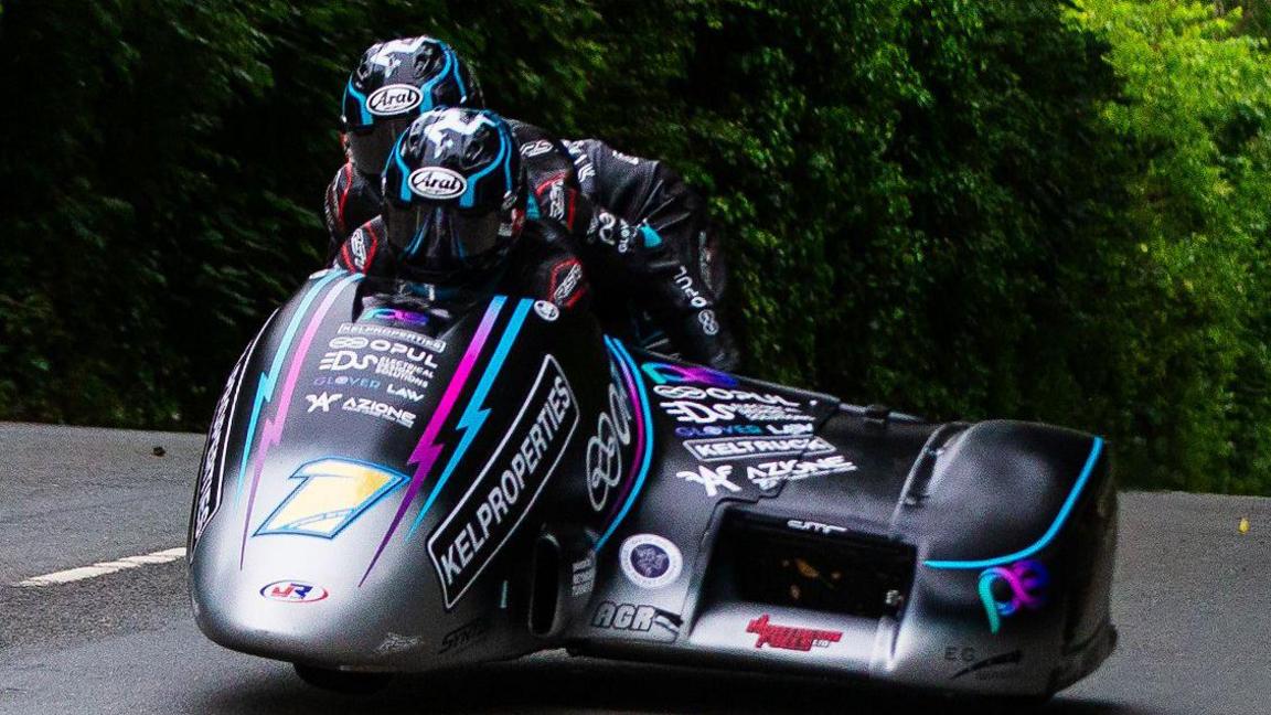 The Crowe brothers racing on their Honda outfit, which is black and silver with splashes of pink and blue.