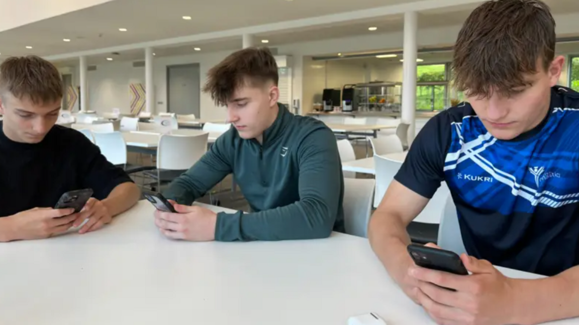 Teenagers at a training camp looking at phones