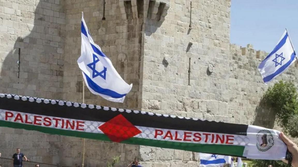 Israeli flag flying next to Palestine scarfs