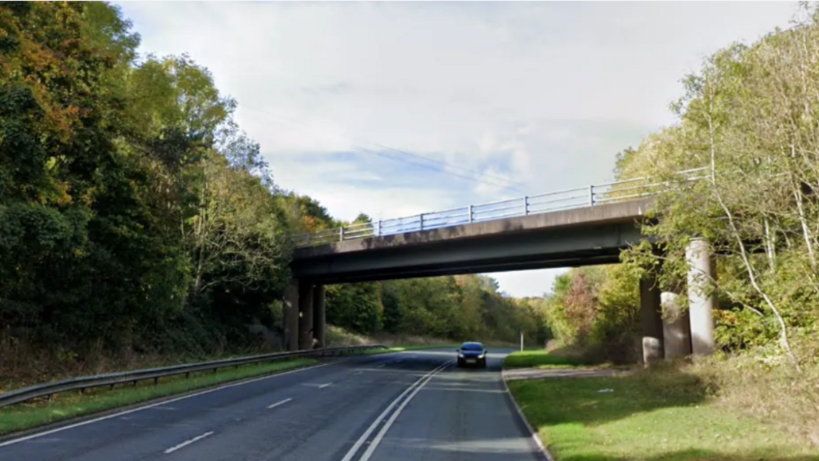 Picture of a car driving under a bridge