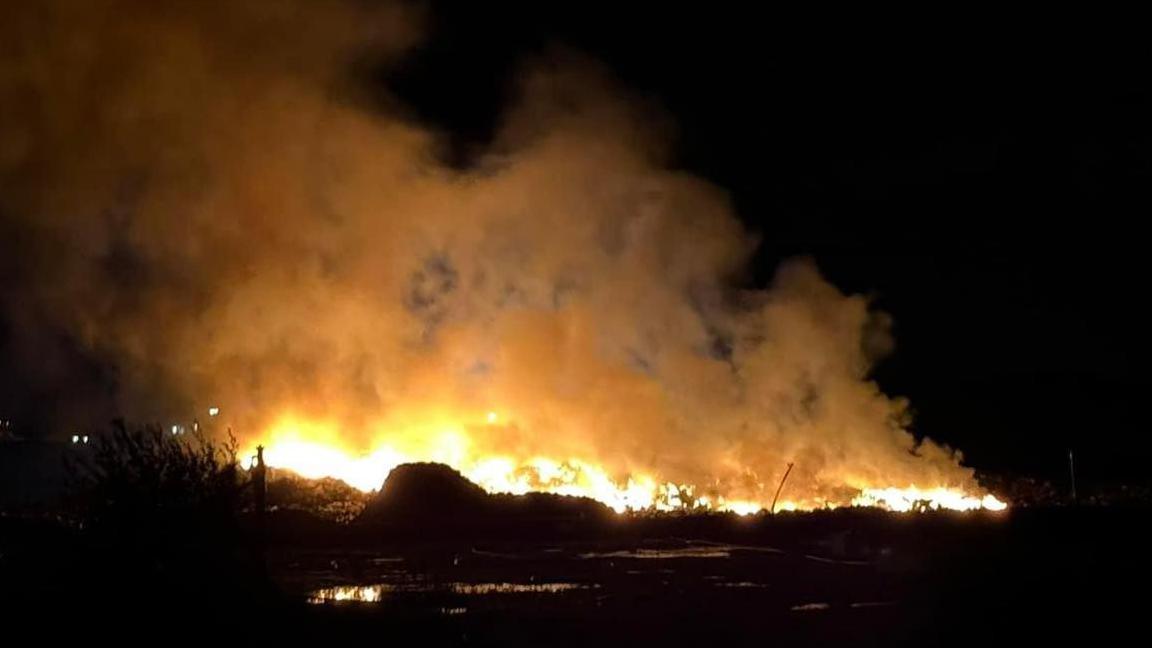 A large fire and smoke against a black sky