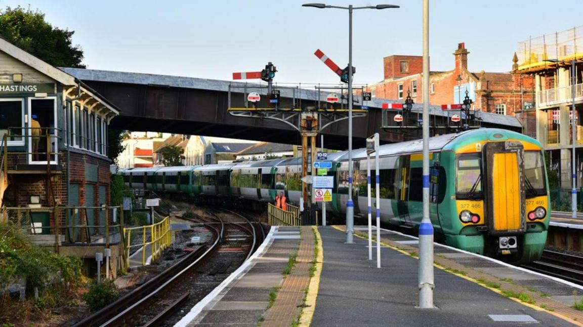 Hastings station, showing a green, white and yellow Southern Railways train at one of the platforms.