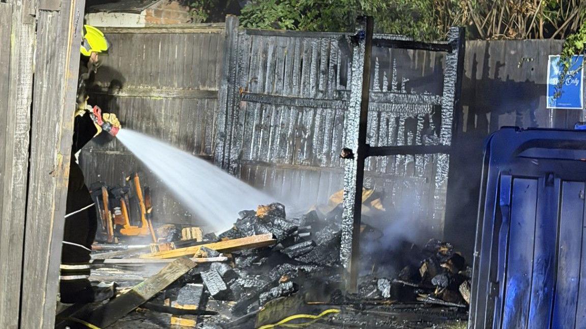 A firefighter hosing down the area