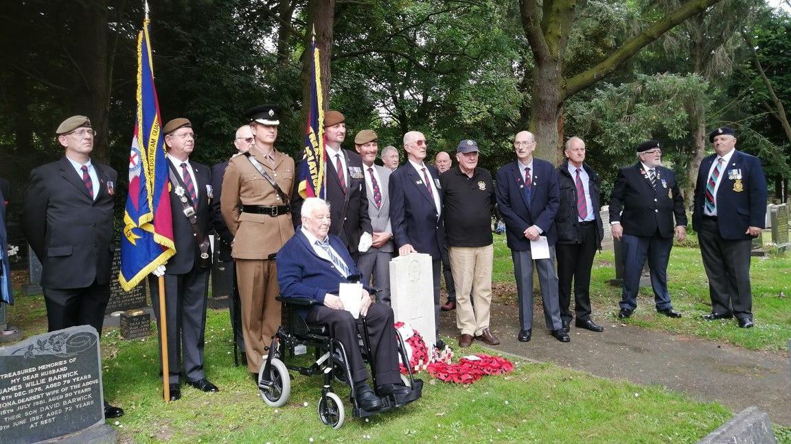 Service attendees standing next to Guardsman Graeme Lawson's grave in Washington at the service on Sunday