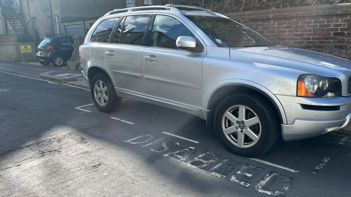 A car parked in the disabled bay. It has the lettering disabled on the road which are slightly faded. There is a sign nearby which says resident permit holders only which is why she was fined