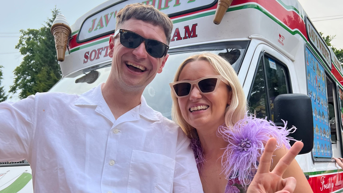 Ryan Losasso and Jade Beaty  - they are both wearing sunglasses. Losasso is wearing a white shirt, Beaty has a feathery purple dress on.