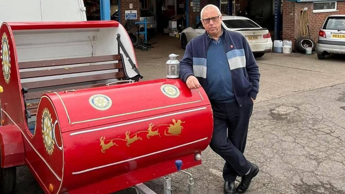 The red sleigh, with rotary club member Dave stood next to it, having its annual check-up outside a garage called Amber Tyres in Ripley. 