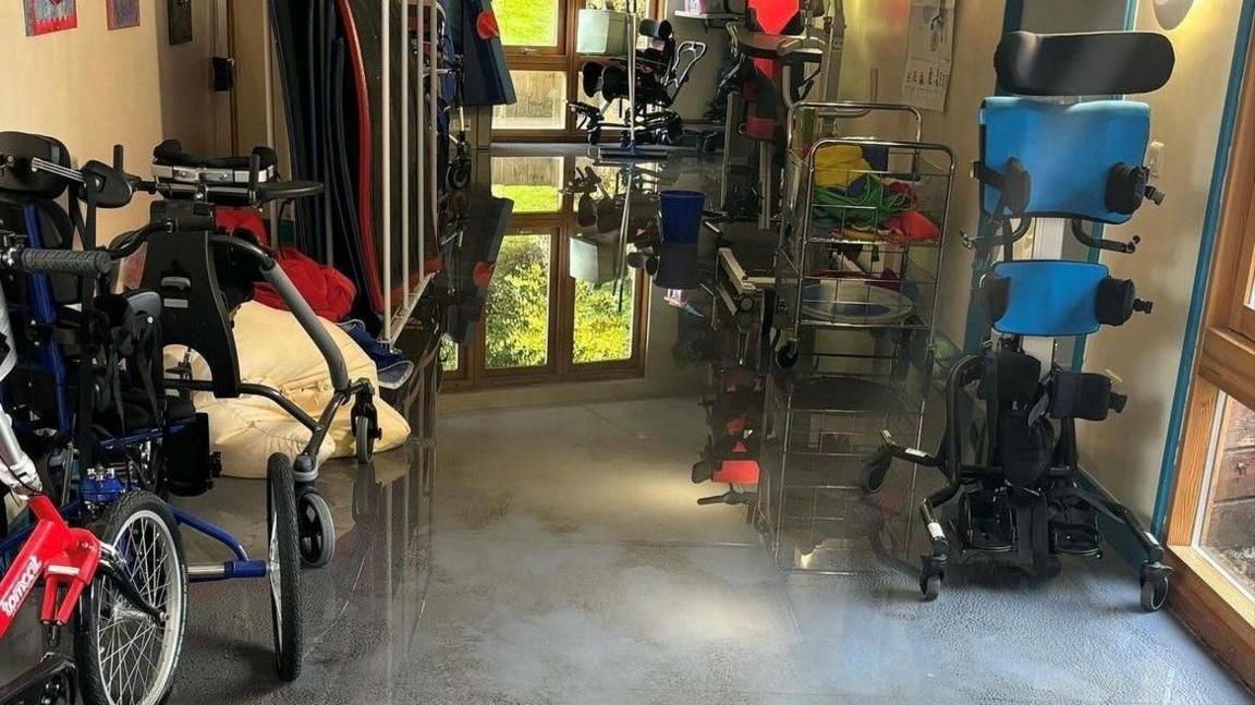 Wheelchairs and other equipment stacked up in a room to keep them out of water on the floor