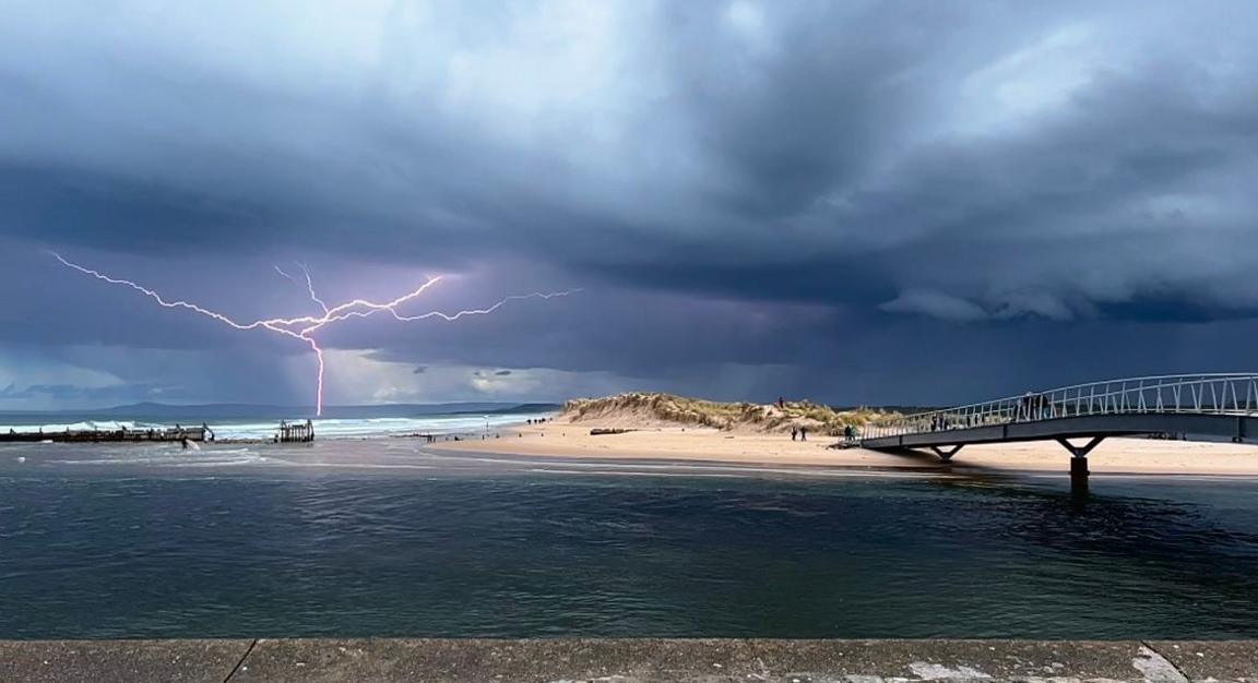 Landscape of lightning striking over a cloudy beach