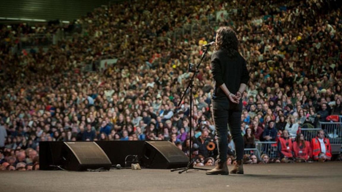 Bardd yn perfformio ar lwyfan