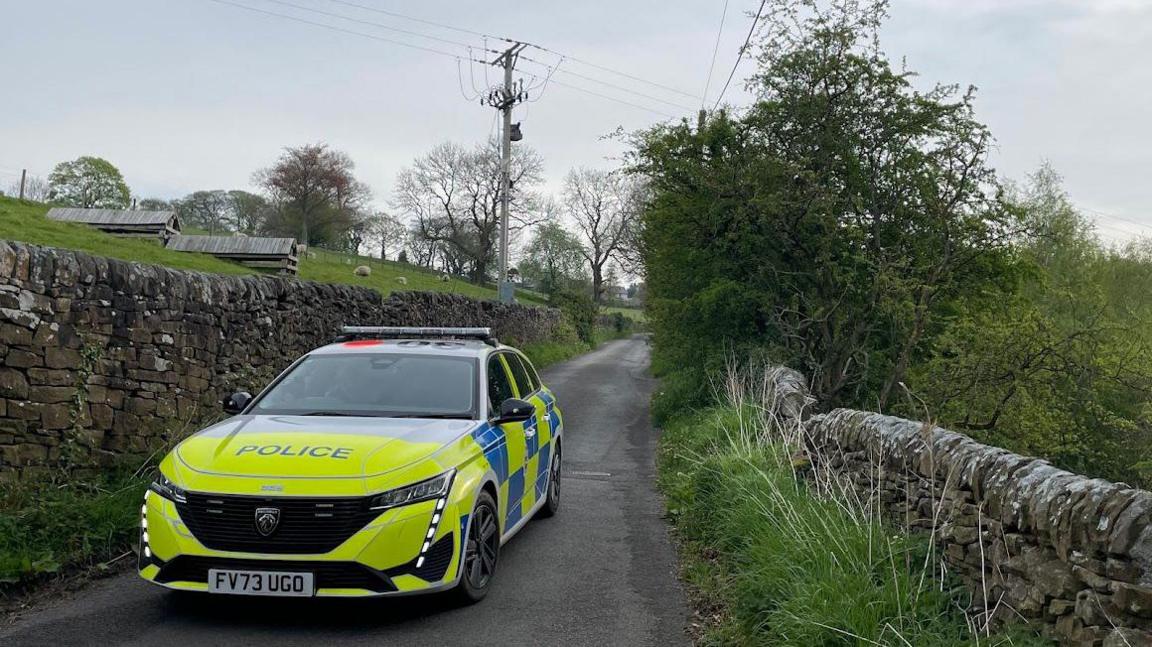 A police car in a single track country road