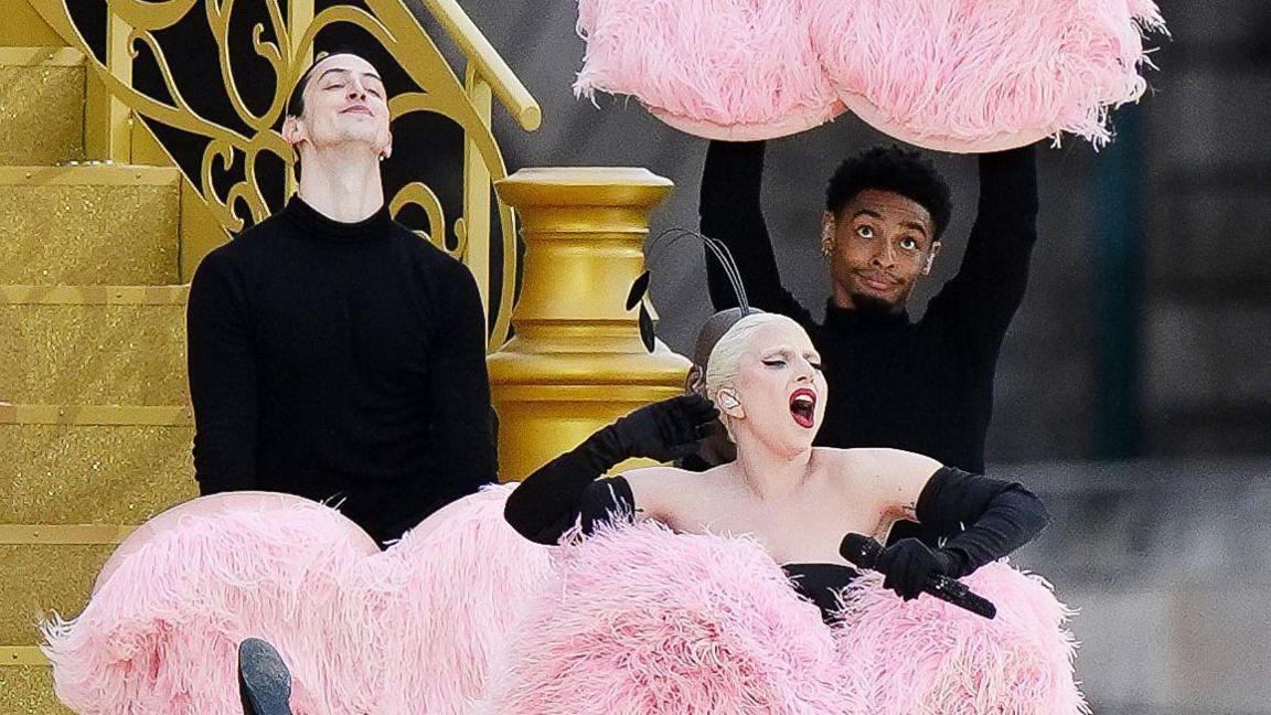 Lady Gaga performing, surrounded by pink pom poms