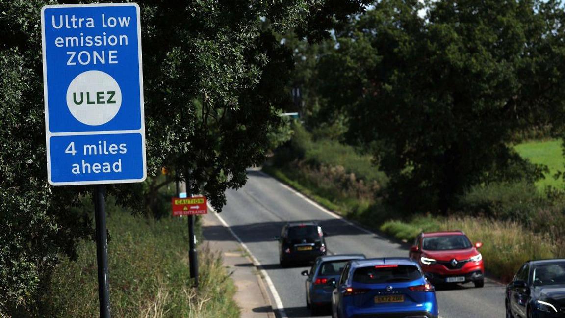 Cars passing a Ulez sign outside the boundary 