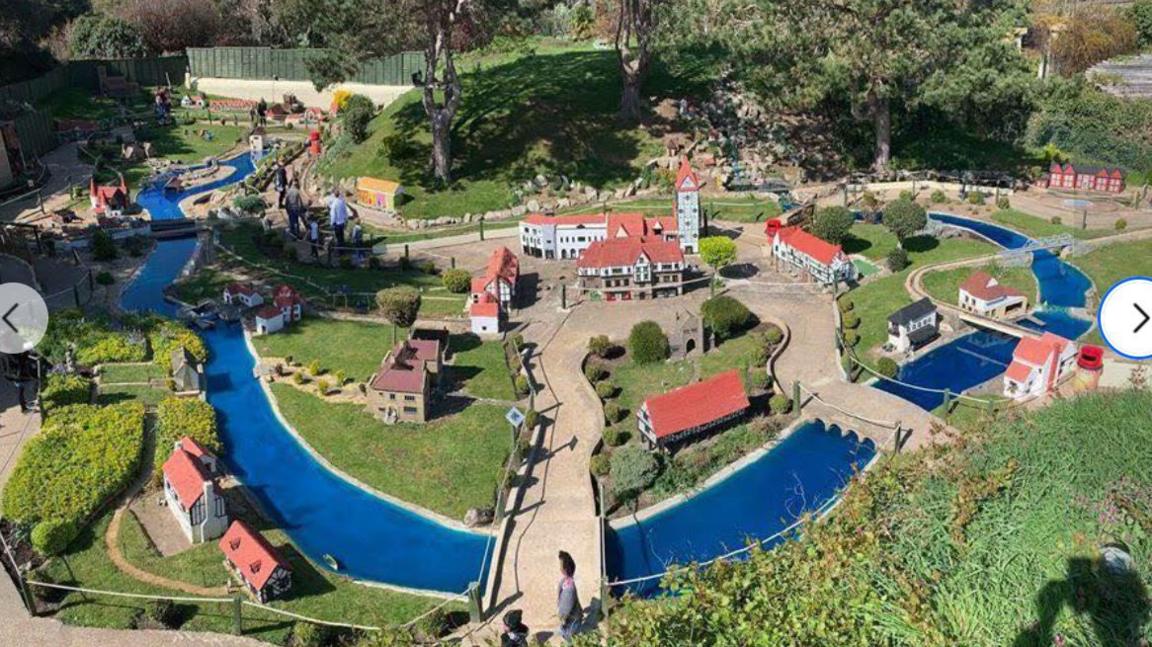 Small-sale model village with numerous buildings around a winding river.