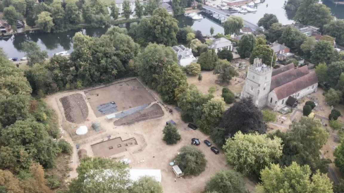 An aerial view of the site, next to a church where archaeologists are digging, with the River Thames close by