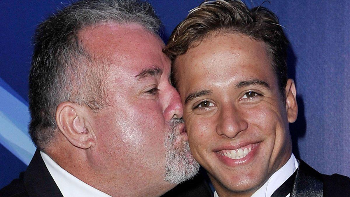 Bert kisses son Chad on the right cheek. They are both wearing black dinner suits.