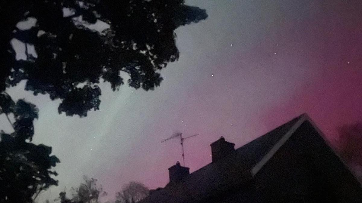 Northern Lights behind house and tree