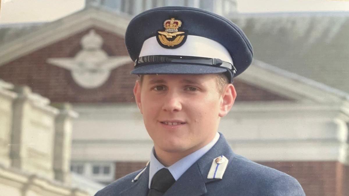 Flt Lt Rob Thomas in his earlier years in RAF uniform. He's wearing a navy suit. 