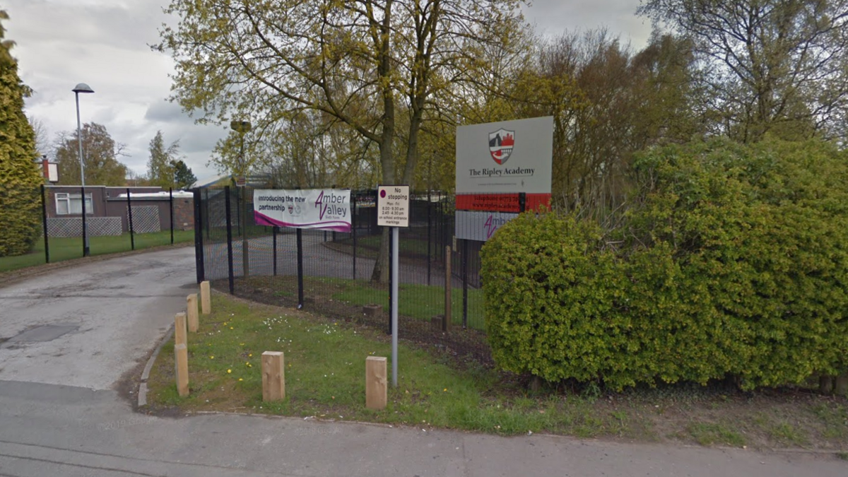 The exterior of The Ripley Academy with a school sign next to the gates