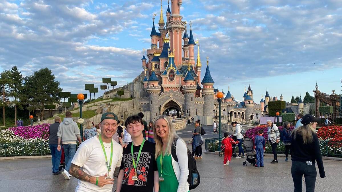 Jay with his mum Kate and taxi driver Tom in front of the Disneyland Paris castle