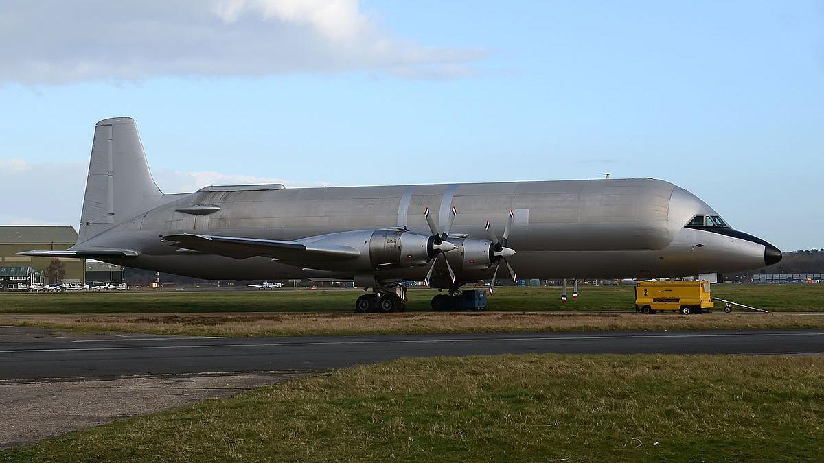 The N447FT Conroy Skymonster cargo plane at Bournemouth Airport. It is a large silver aircraft with four turboprop engines and an enlarged fuselage.