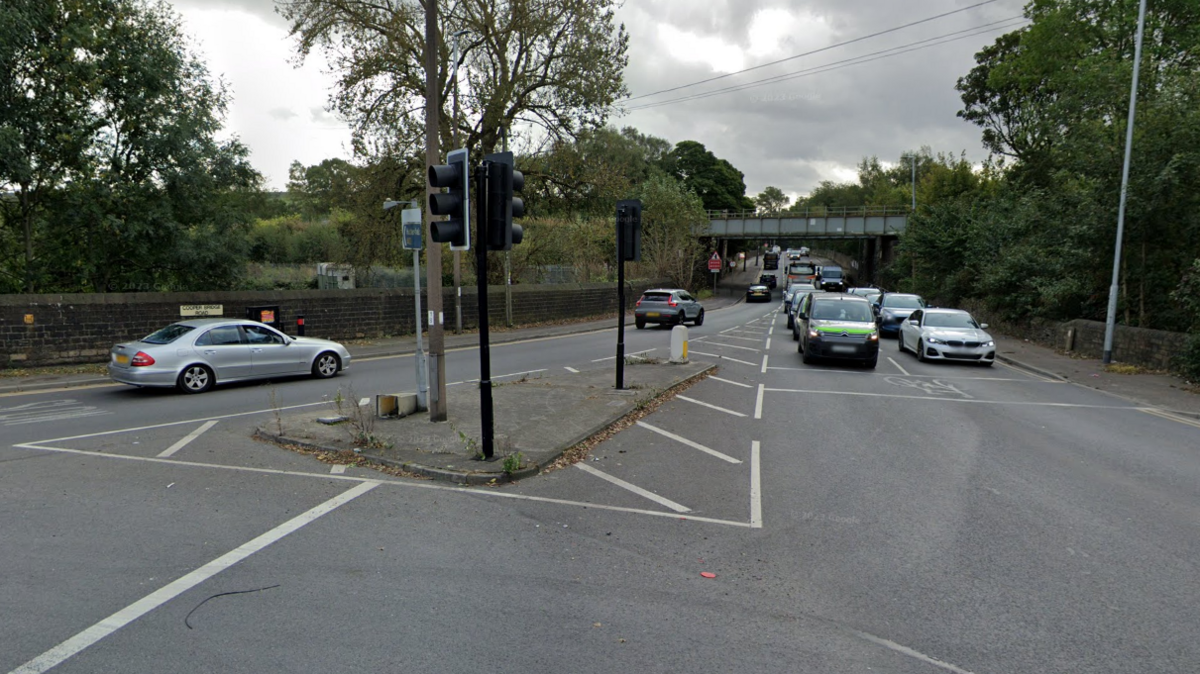 Cars drive along a road leading away from a roundabout