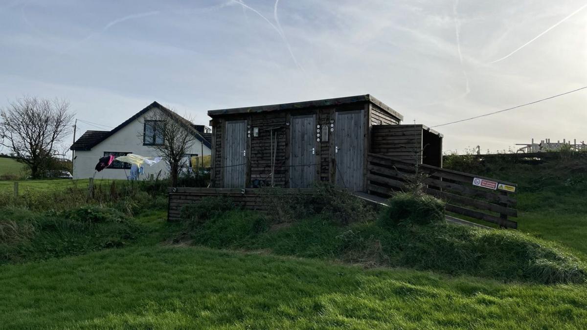 Mobile toilet and shower block at Tŷ Bugail, with house in the background