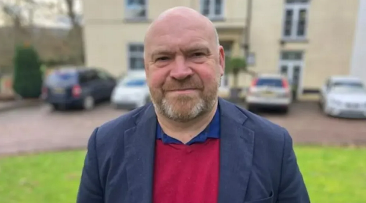 Bill Revans in front of a building looking at camera