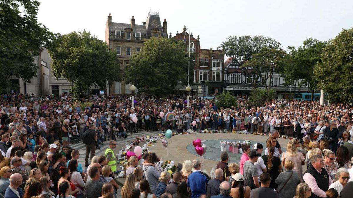 Crowds gather at a vigil in Southport town centre in front of the Atkinson Theatre