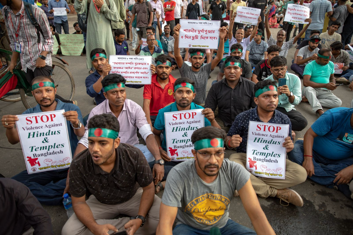 People protesting in Bangladesh after the resignation of Sheikh Hasina. They hold up signs saying stop violence against Hindus and Temples Bangladesh on 8th August 2024. 