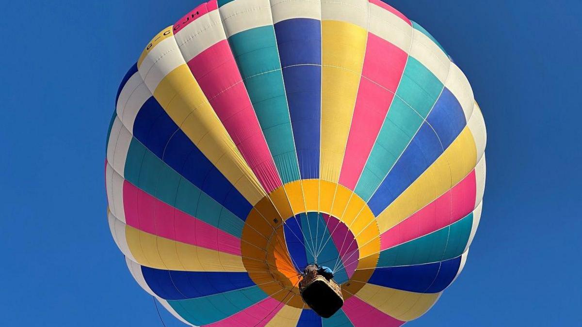 A multi-coloured hot air balloon in the sky