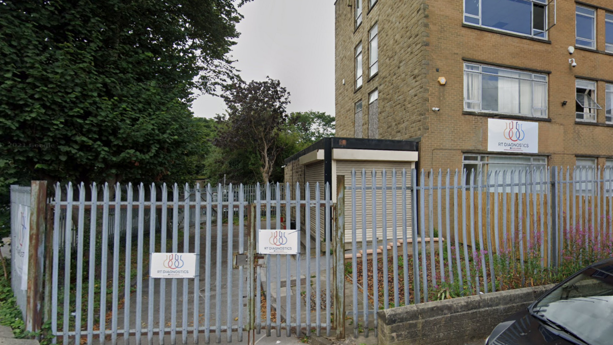 A large office-type building with a sharp-pointed metal fence around the front.