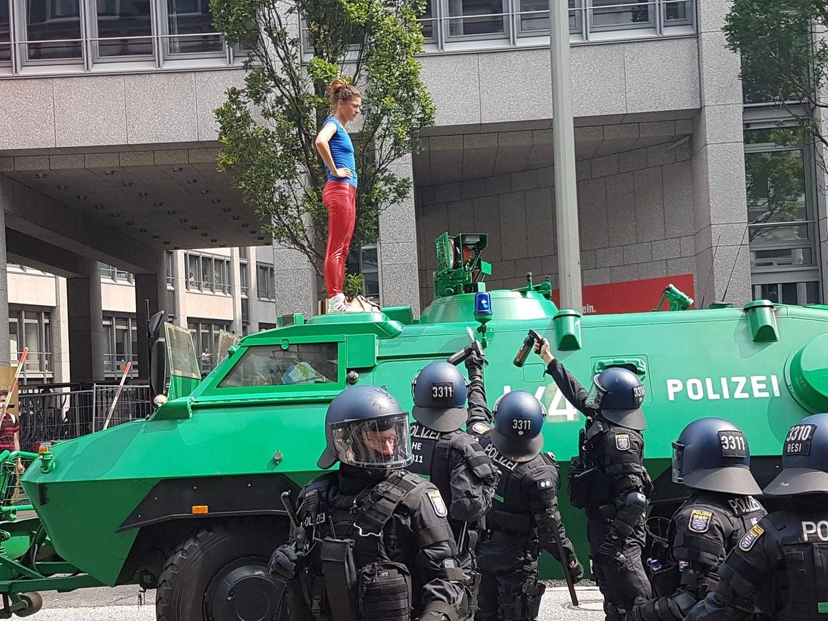 Police use pepper spray to against protester standing on an armoured car in Hamburg, 7 July