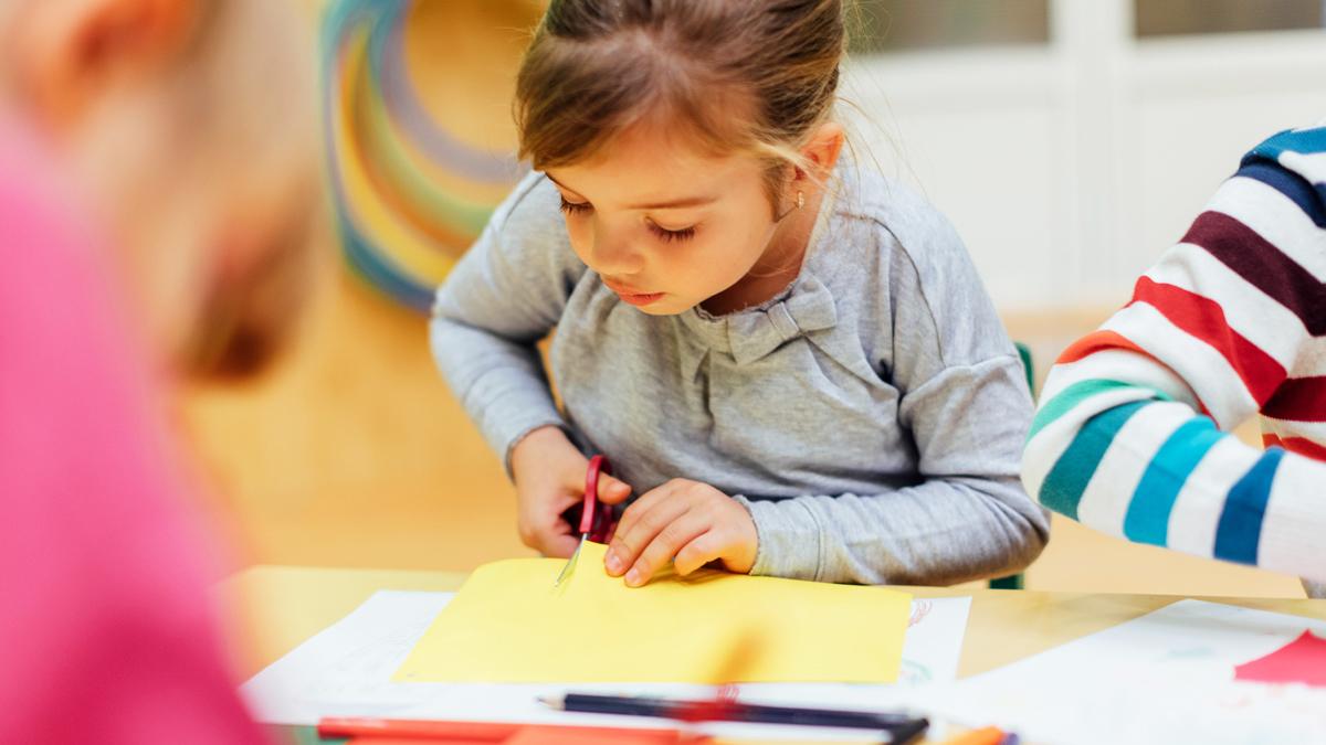 Young girl cutting yellow paper