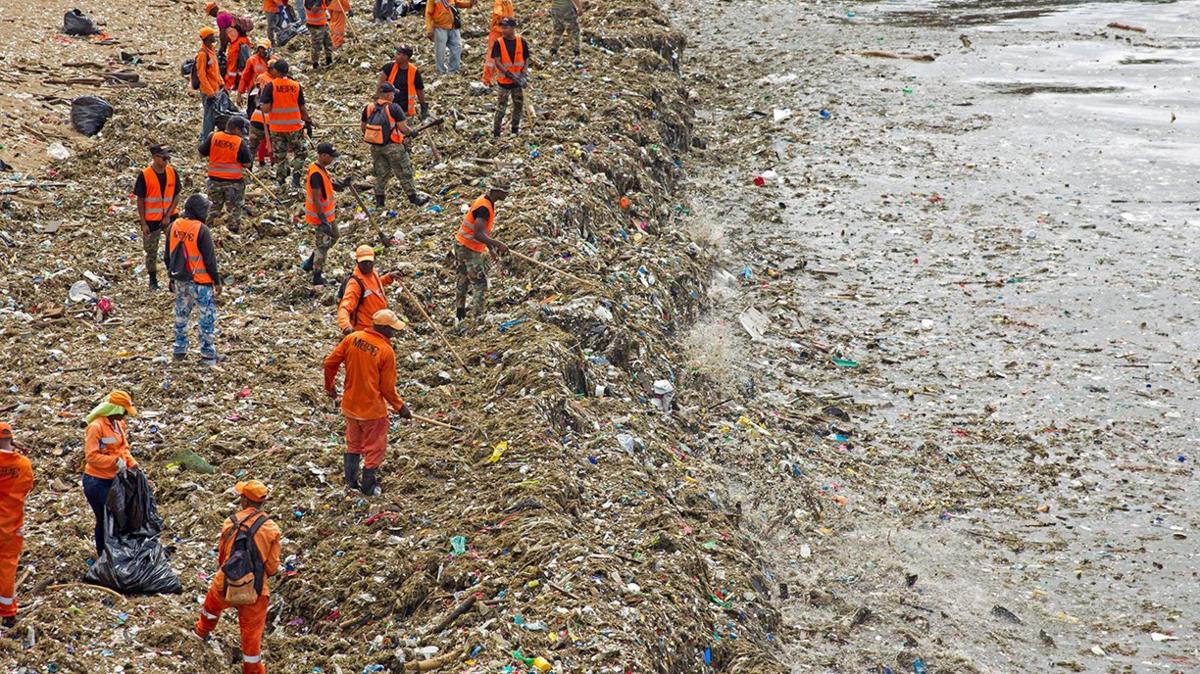 Workers on a beach in the Dominican Republic clearing up the rubbish that has been left from a recent storm