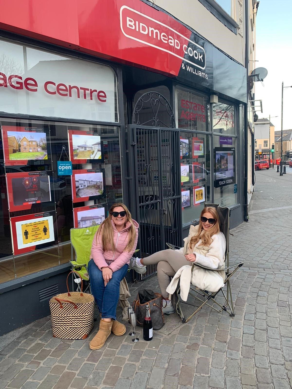 Two women outside estate agent