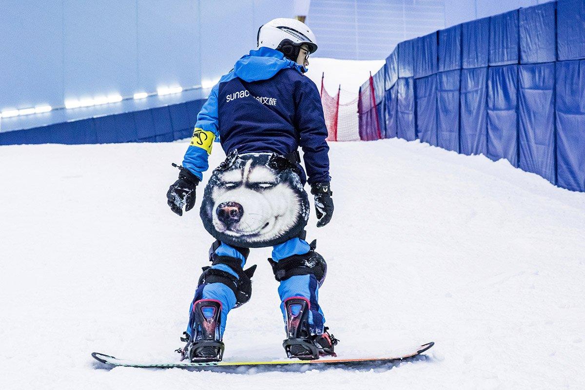 A snowboarder with a wolf on his outfit