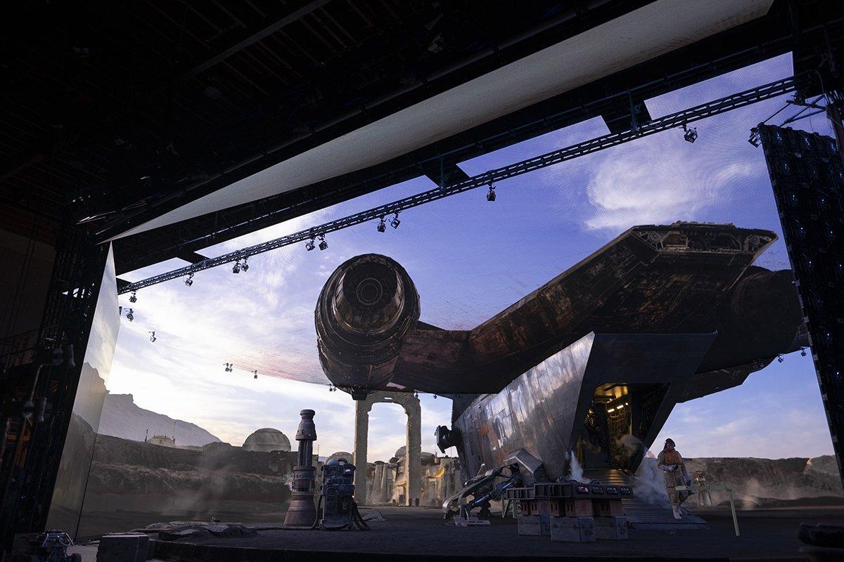 A space ship in front of a digital wall and virtual set.