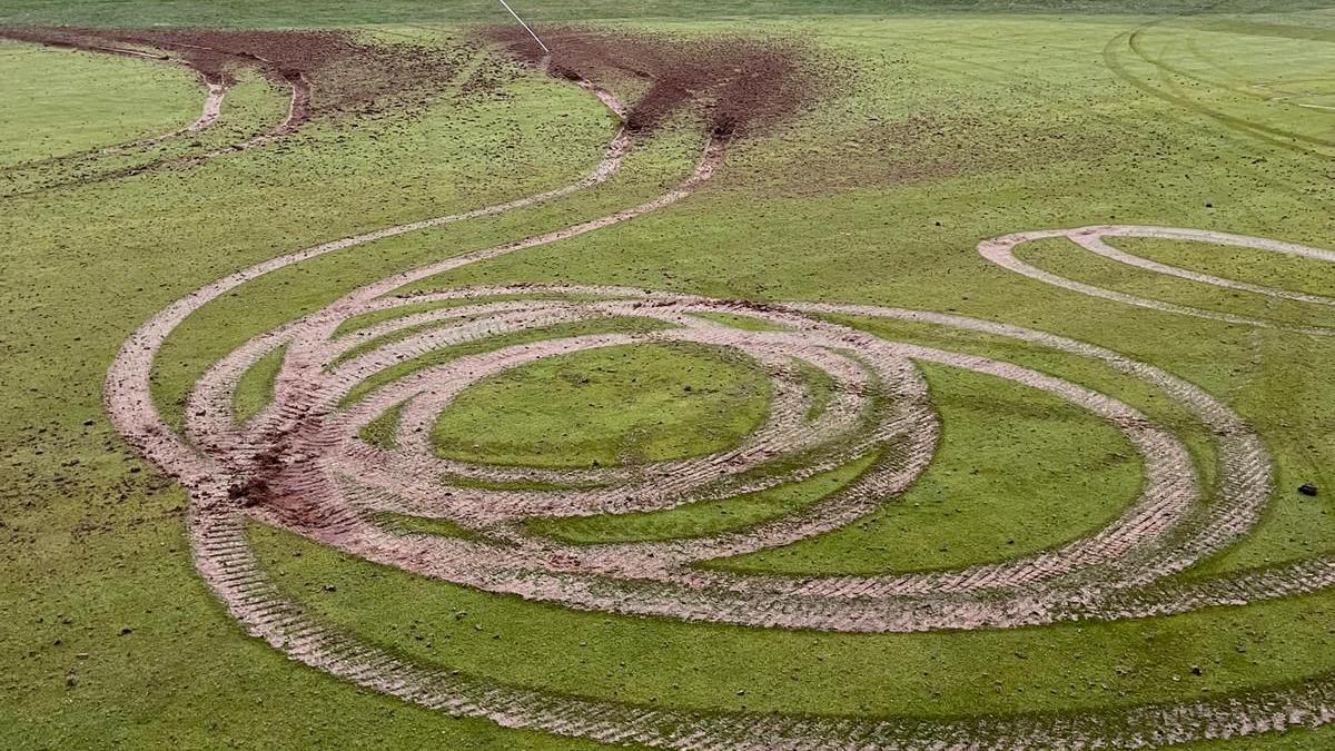 Circular tyre tracks on a golf course - about half a dozen circles have been created on a mown area of grass